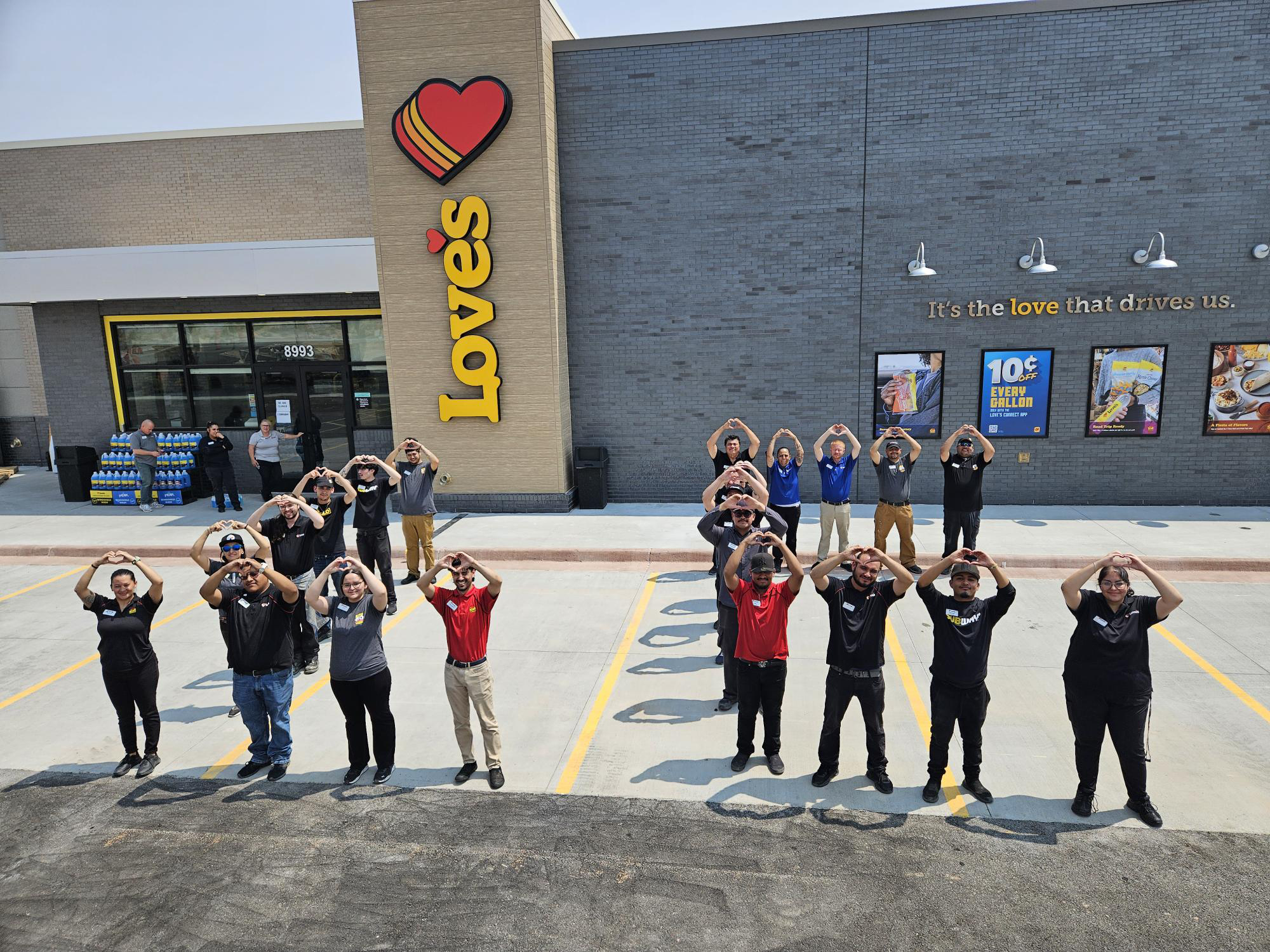 Employees making a heart symbol outside the Las Cruces Love's Travel Stop