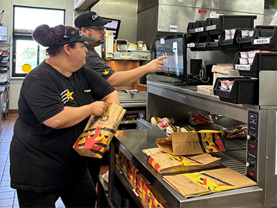 Love's employees putting food together at a Carl's Jr restaurant